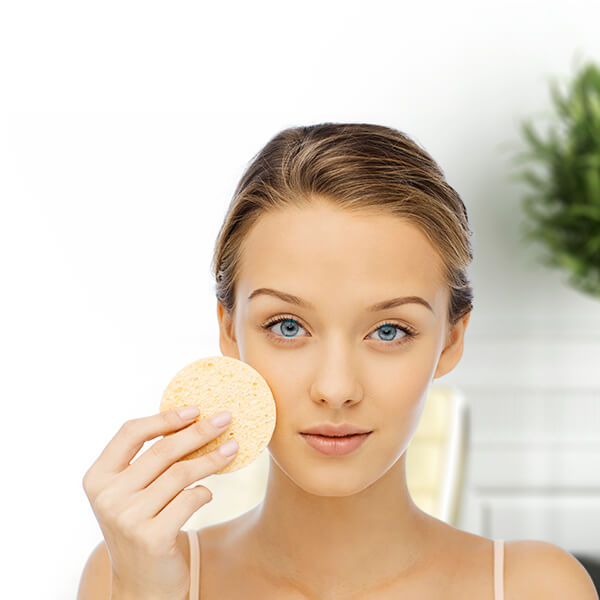 Mulher aplicando esponja facial em rotina de cuidados com máscaras faciais hidratantes para pele saudável