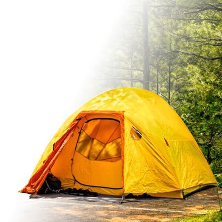 Tenda de camping amarela montada em área natural com árvores para comprar artigos de camping e montanha
